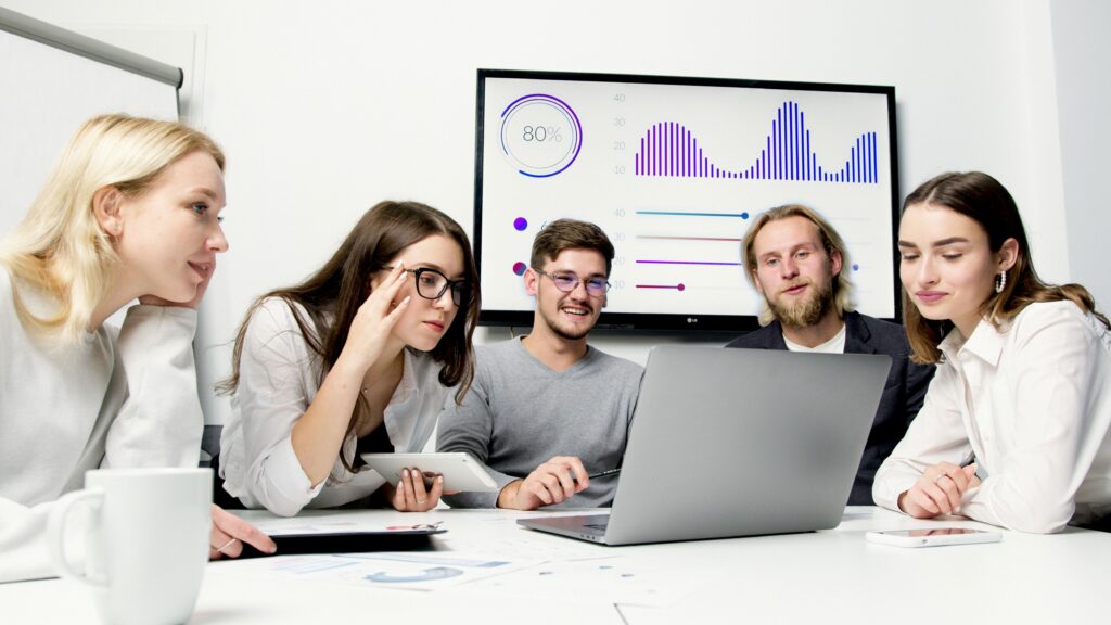 Mehrere Personen schauen auf ein Laptop