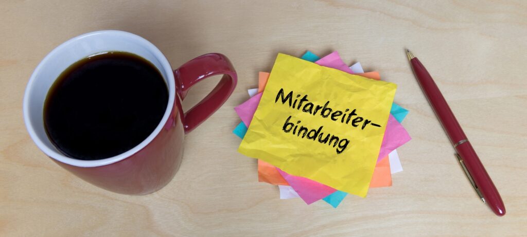 Schreibtisch mit Mitarbeiterbindung-Notiz | Chiropraxis Berlin